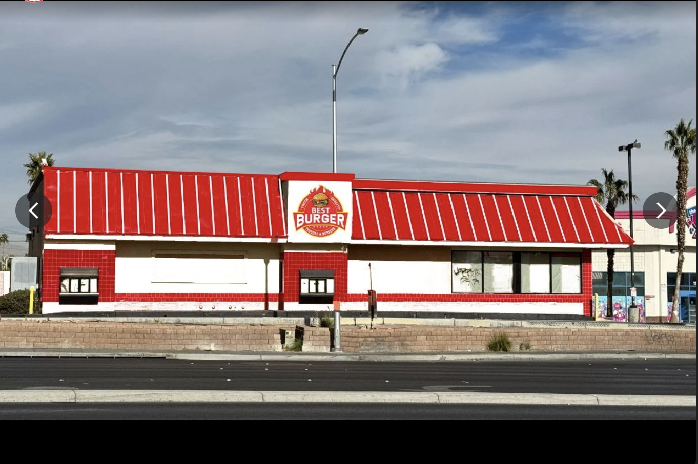 Best Burger's daytime storefront with a red mansard roof, palm trees and a wide Las Vegas boulevard
