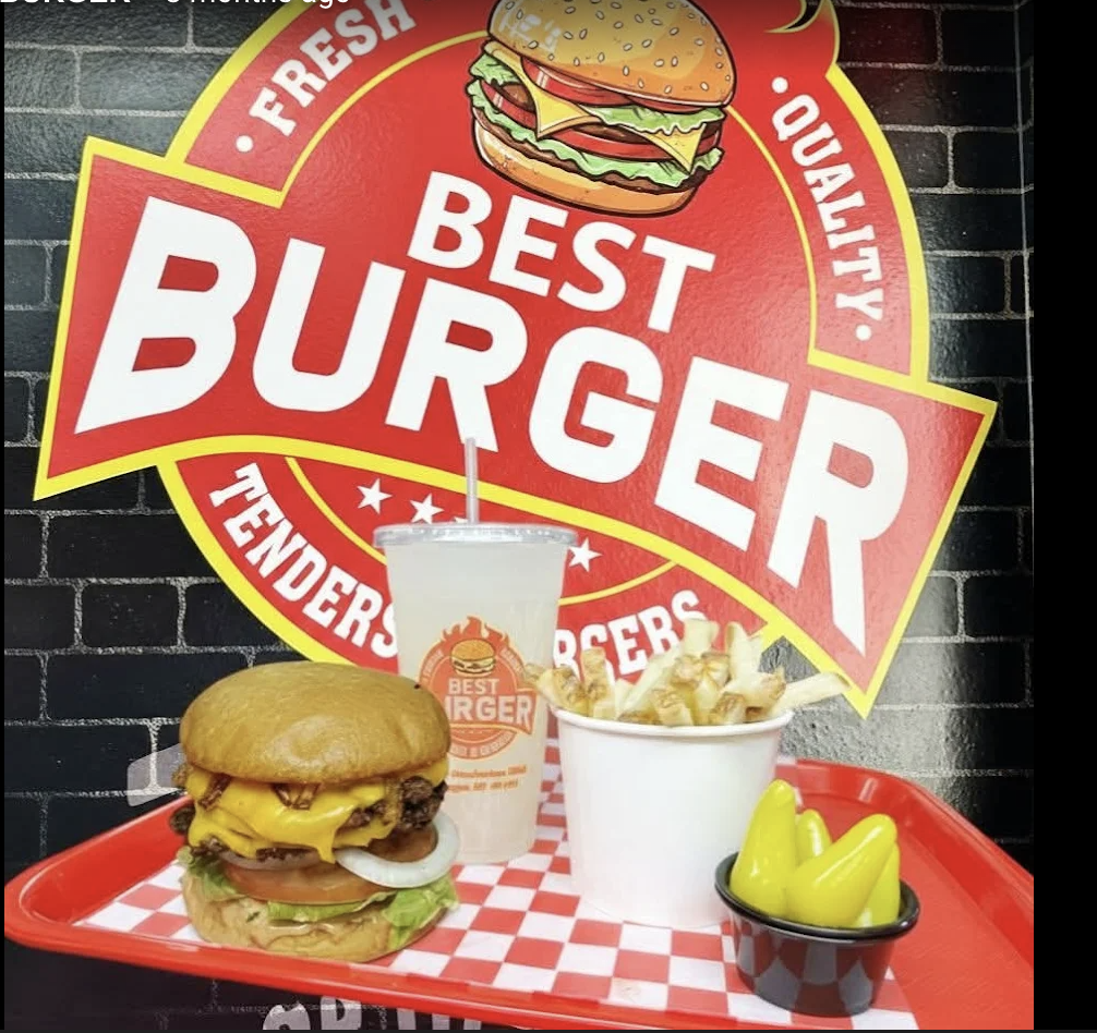 The painted Best Burger wall badge above a red tray holding a burger, fries and a drink on a checkered liner